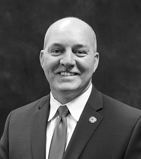 Headshot of Executive Director Matt Russell. Black and white.