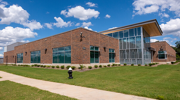 Exterior of Dothan RTC> Large brick building with stained glass windows.